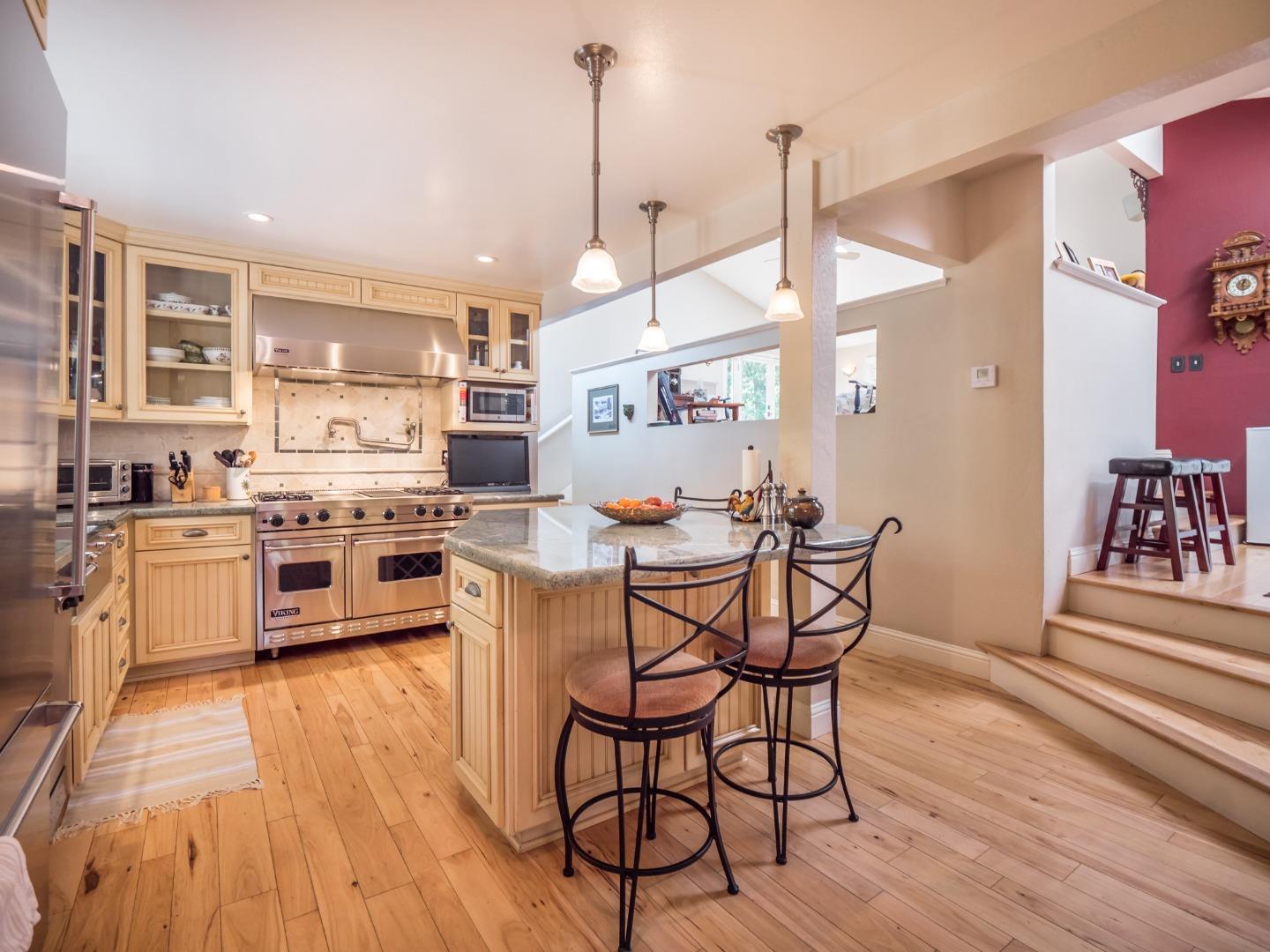 12445 Alba Road Ben Lomond, CA 95005 - Photo 23 of 37 a kitchen with stainless steel appliances a stove a sink dishwasher and a dining table with wooden floor