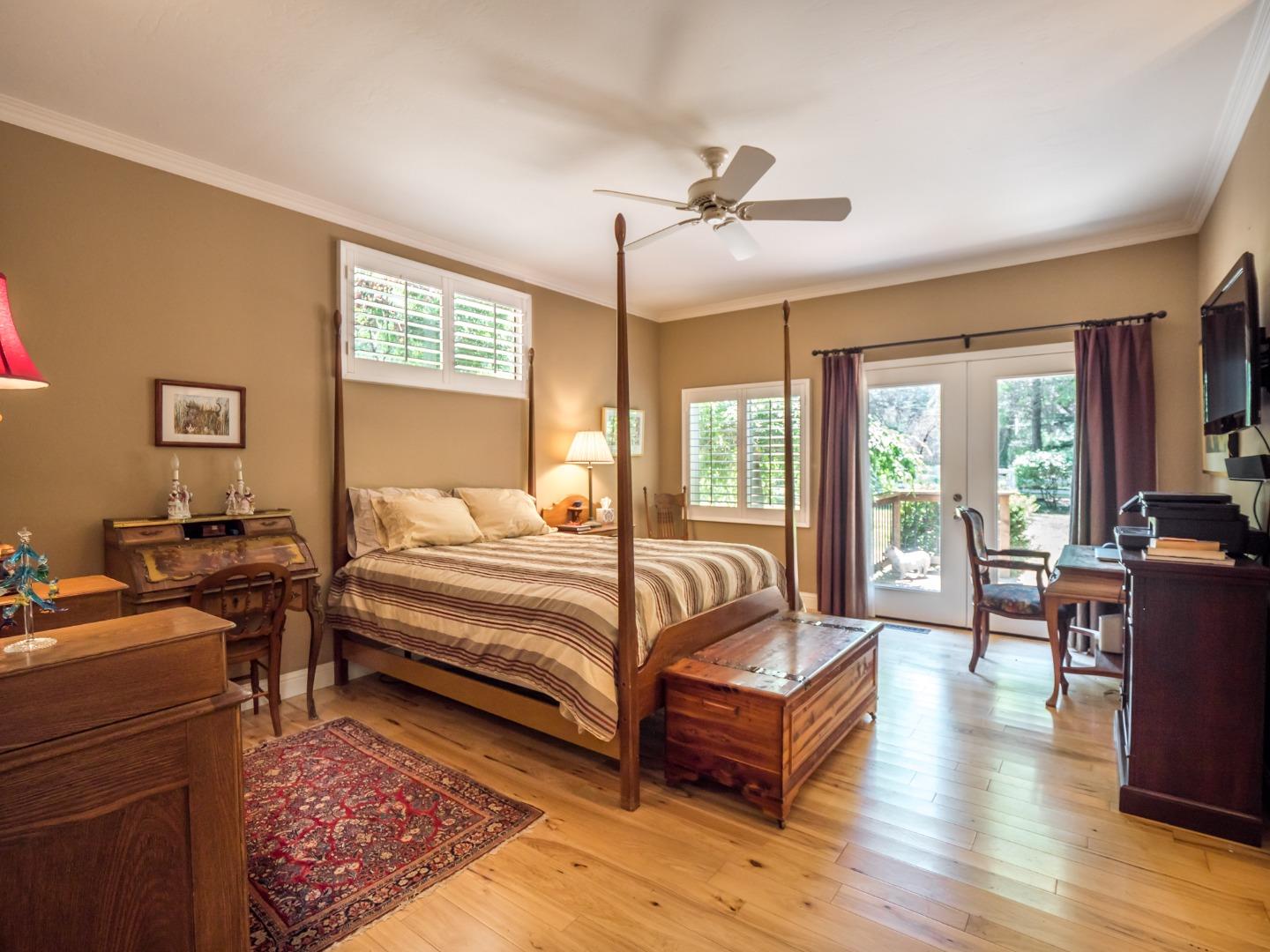 12445 Alba Road Ben Lomond, CA 95005 - Photo 28 of 37 a spacious bedroom with a bed a table and large windows