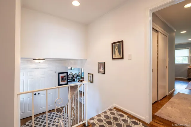 a walk in closet with wooden floor