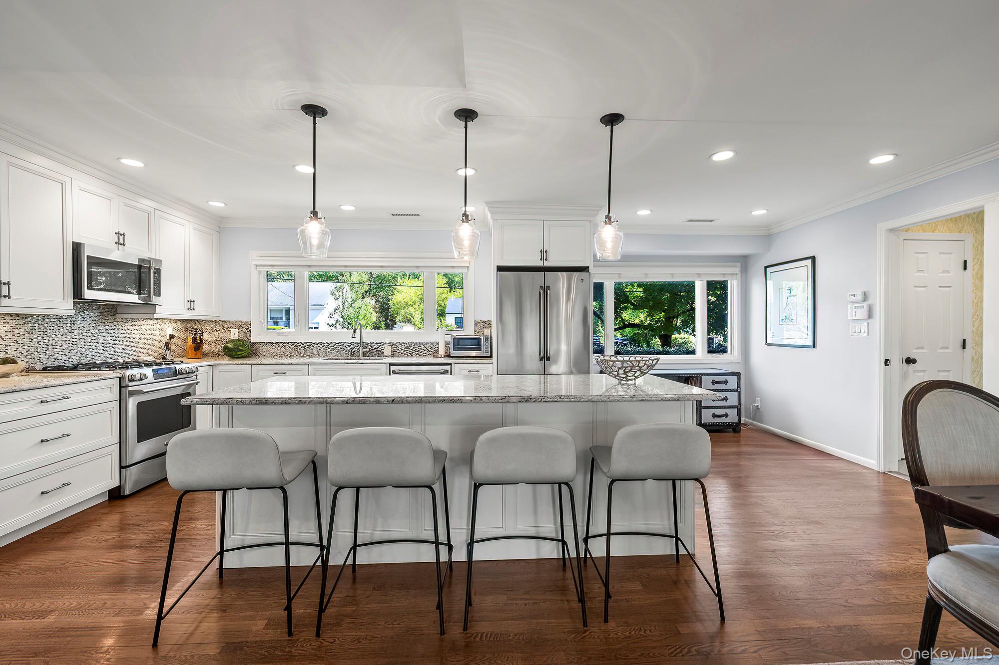 53 Country Ridge Drive Rye Brook, NY 10573 - Photo 5 of 50 a kitchen with kitchen island granite countertop a table chairs stove a sink and a window