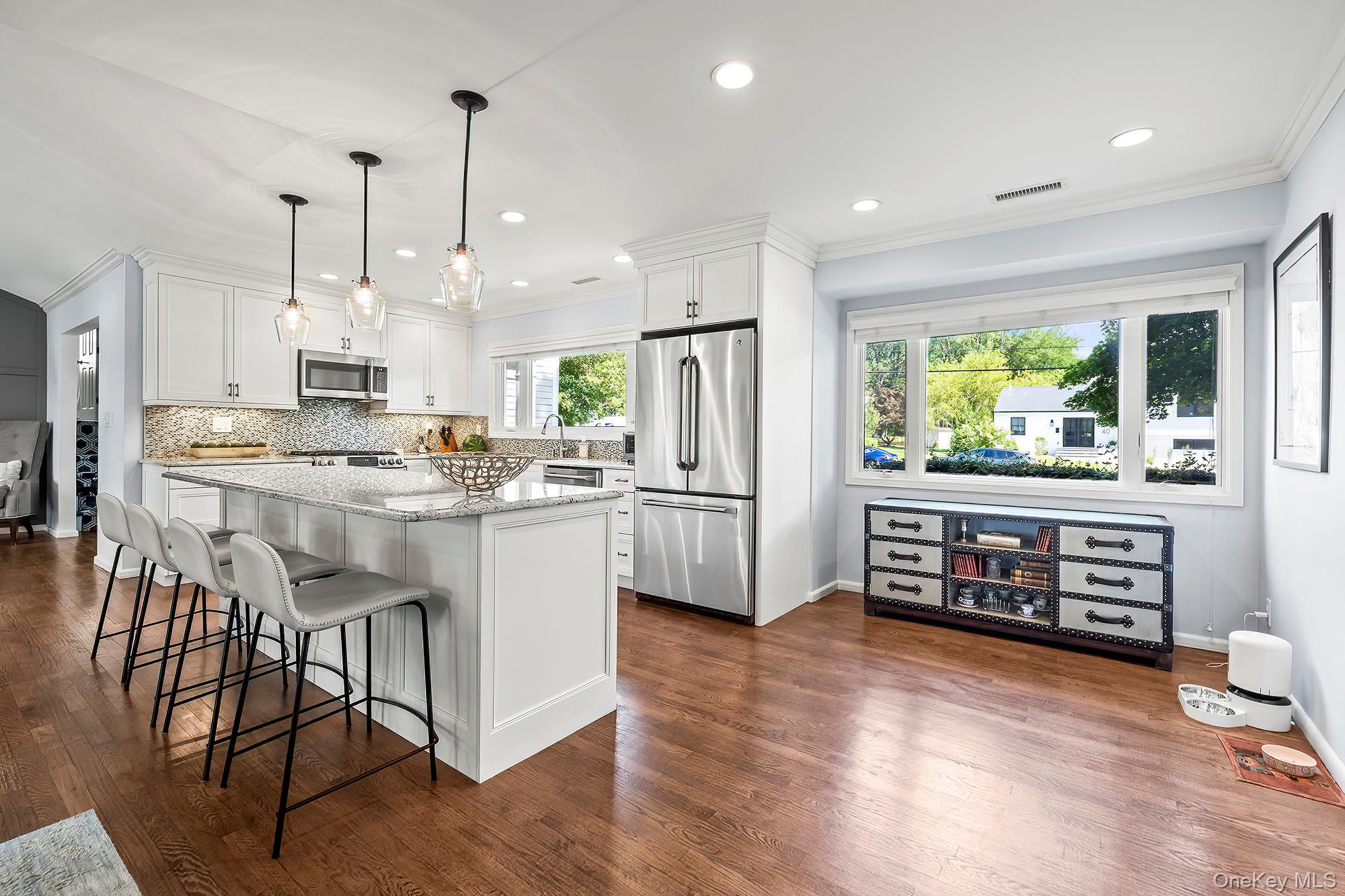 53 Country Ridge Drive Rye Brook, NY 10573 - Photo 6 of 50 a kitchen with stainless steel appliances kitchen island granite countertop a stove a refrigerator a sink a dining table and chairs with wooden floor