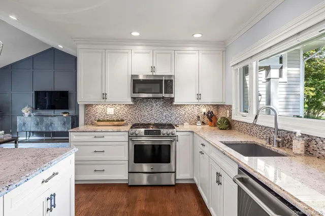 a kitchen with stainless steel appliances granite countertop a sink stove and refrigerator