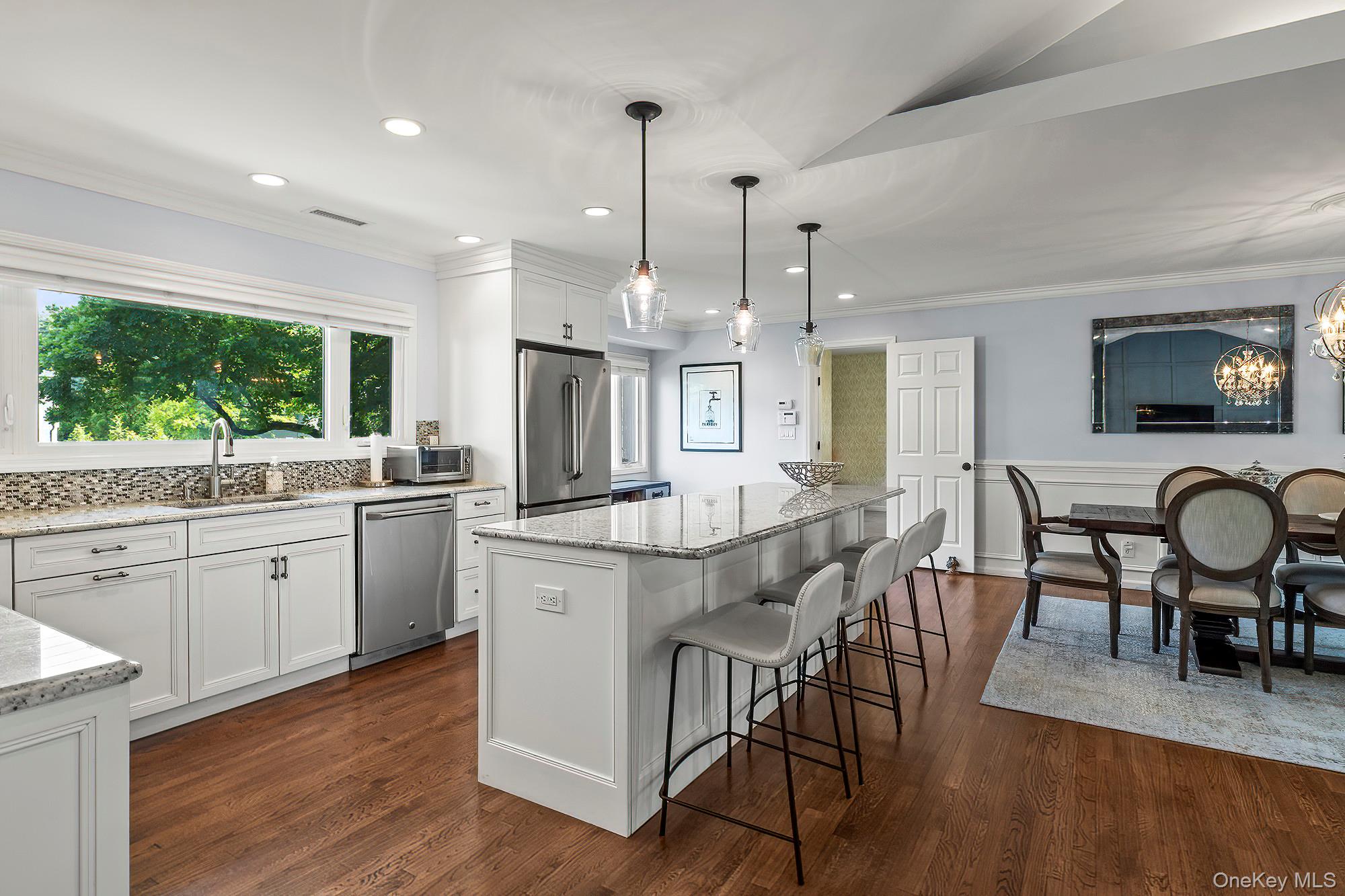 53 Country Ridge Drive Rye Brook, NY 10573 - Photo 8 of 50 a kitchen with stainless steel appliances granite countertop a kitchen island hardwood floor sink stove dining table and chairs