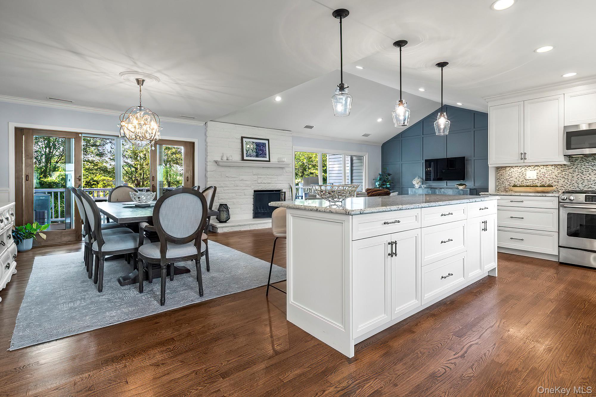 53 Country Ridge Drive Rye Brook, NY 10573 - Photo 9 of 50 a large white kitchen with granite countertop a stove a sink a dining table and chairs with wooden floor