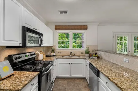 a kitchen with a sink stove top oven and cabinets