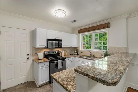 a kitchen with stainless steel appliances granite countertop a sink stove and refrigerator