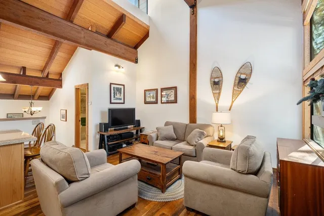 a living room with furniture a flat screen tv and a large window