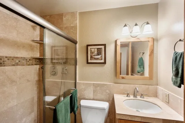 a bathroom with a sink vanity mirror and toilet