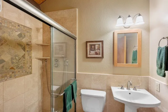 a bathroom with a sink a toilet and shower