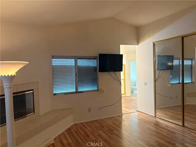 a view of a livingroom with wooden floor and a fireplace