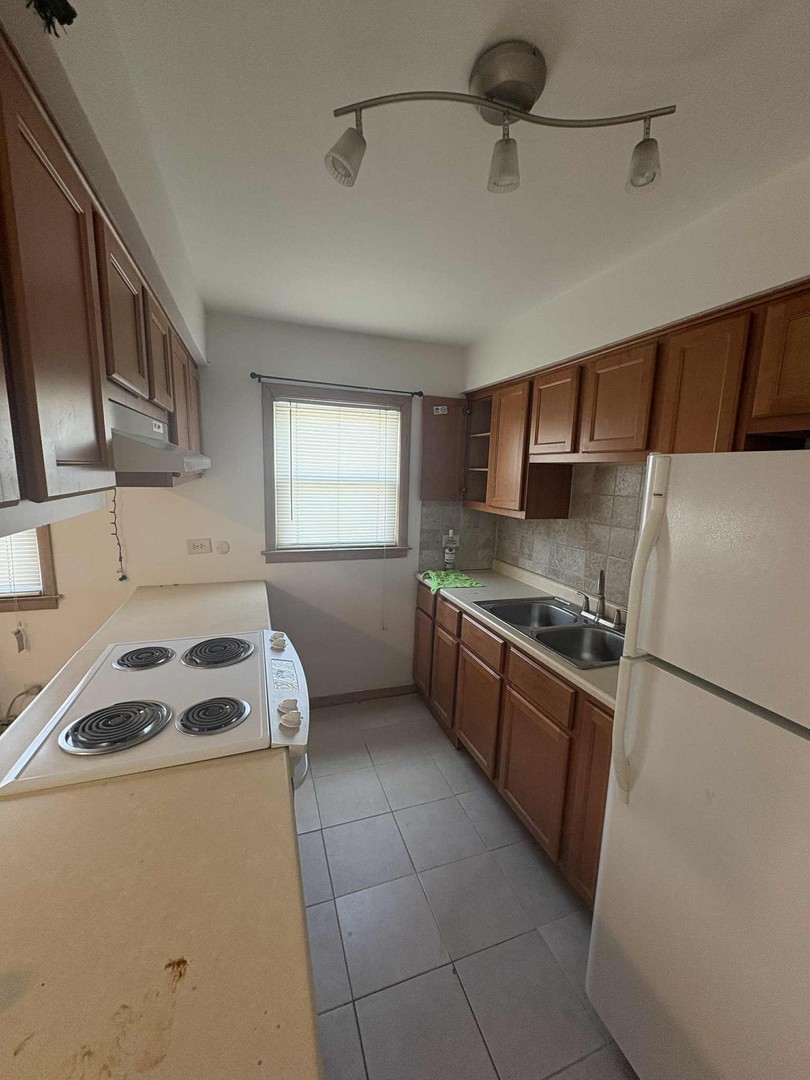 8000 South Pulaski Road, Unit 201 Chicago, IL 60652 - Photo 9 of 9 a kitchen with a sink a stove and a refrigerator