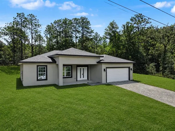 a front view of a house with yard and trees