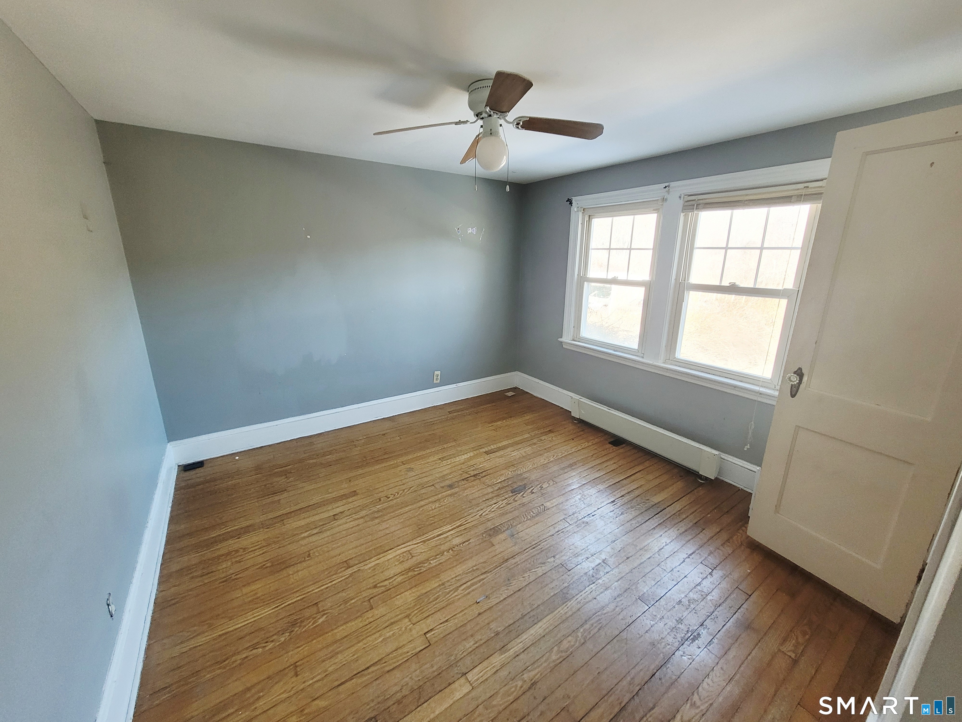 96 Tudor Street Waterbury, CT 06704 - Photo 12 of 15 an empty room with wooden floor and windows