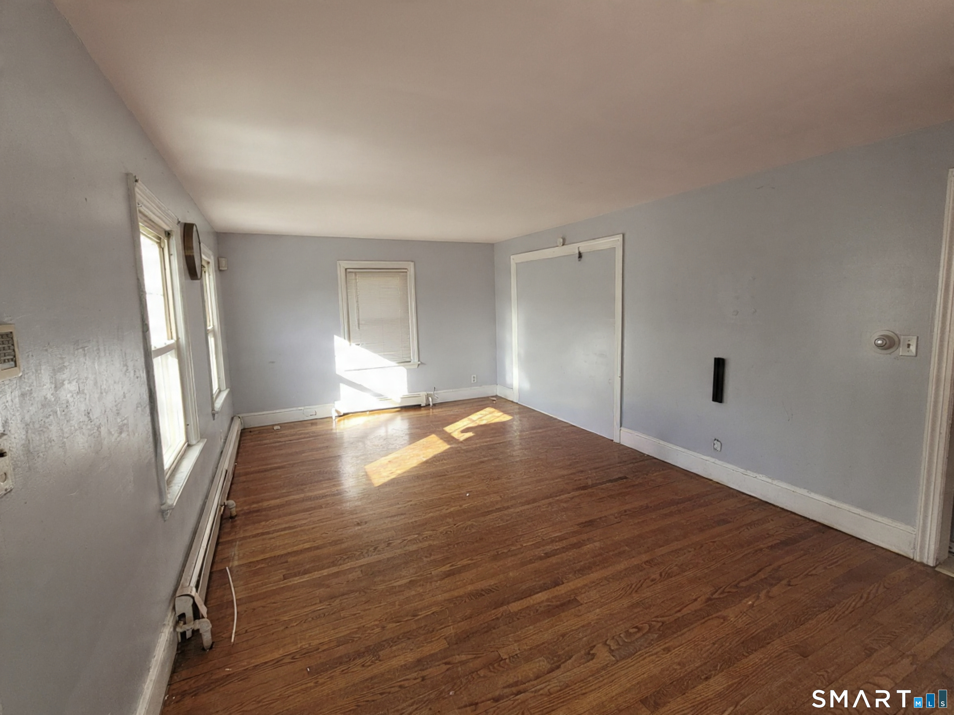 96 Tudor Street Waterbury, CT 06704 - Photo 2 of 15 an empty room with wooden floor and windows