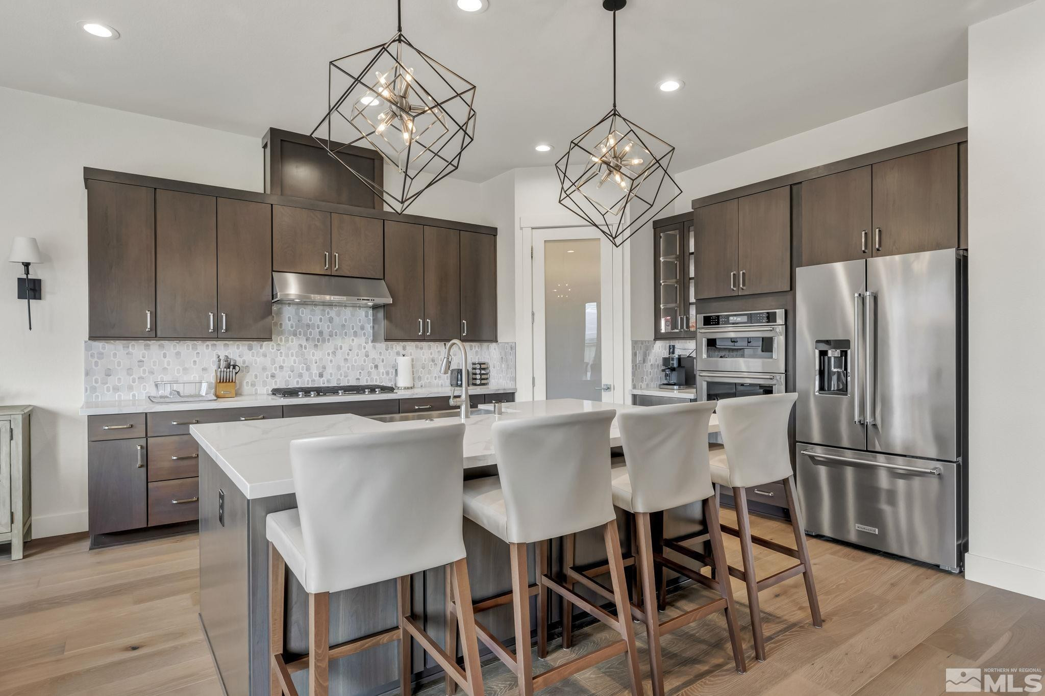9525 Copper Sky Drive Reno, NV 89521 - Photo 16 of 40 a kitchen with stainless steel appliances a dining table chairs sink and cabinets