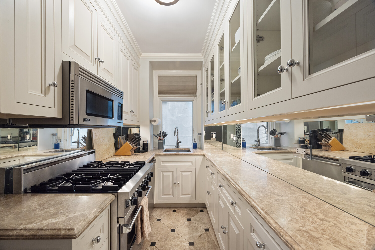 125 East 74th Street, Unit 4A Manhattan, NY 10021 - Photo 5 of 10 a kitchen with a stove a sink and a microwave