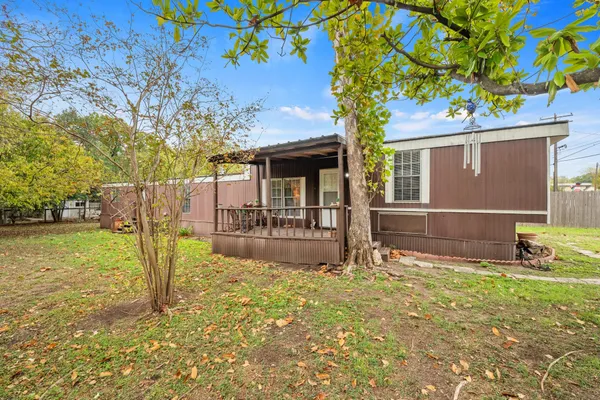 a view of a house with backyard and a tree
