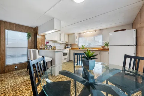a dining room filled chandelier and wooden floor