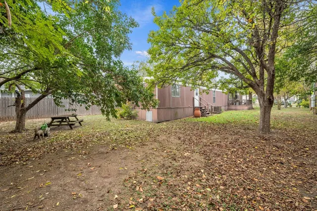 a view of a backyard with a patio and wooden fence