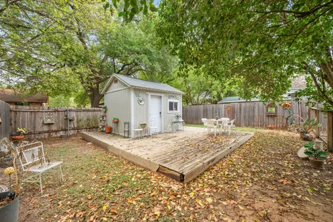 a view of a backyard with a patio and wooden fence