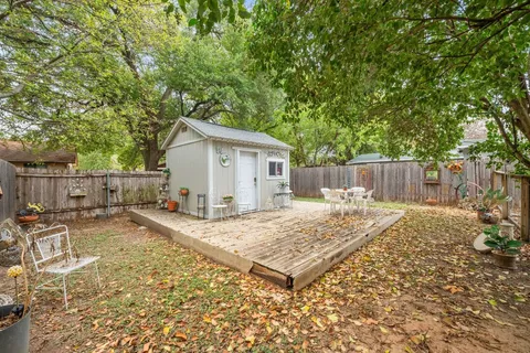 a view of a patio with table and chairs with wooden floor and fence