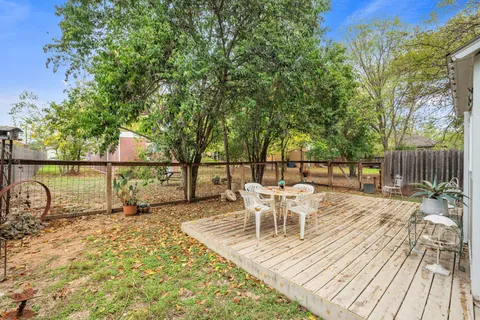 a view of a patio with table and chairs with wooden floor and fence