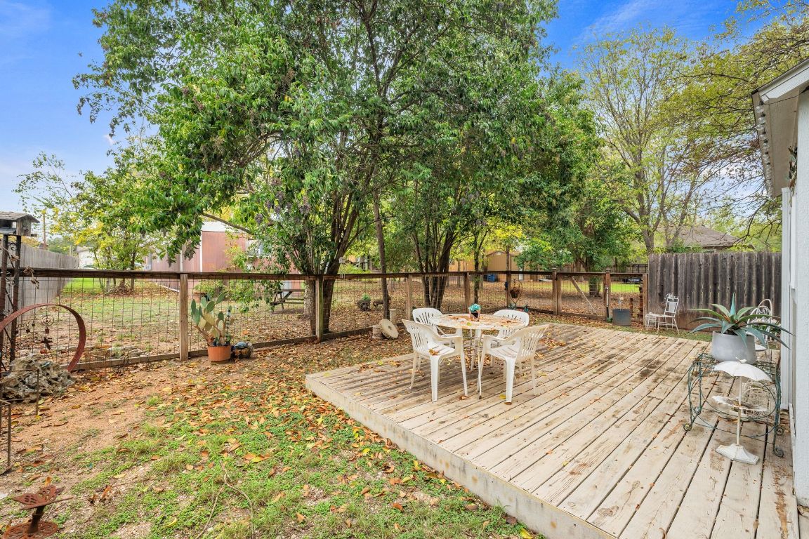 5811 Nancy Drive Austin, TX 78745 - Photo 24 of 26 a view of a patio with table and chairs with wooden floor and fence