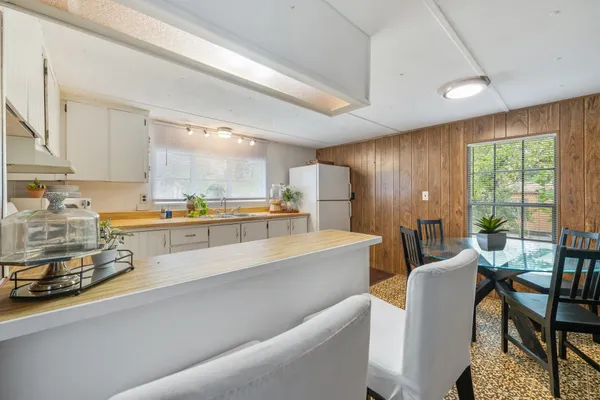 a large white kitchen with a large window
