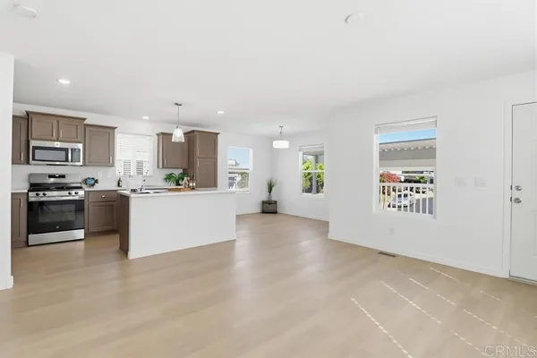 a view of kitchen with kitchen island a sink stainless steel appliances and cabinets