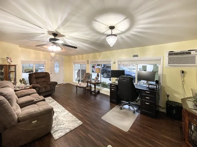 a living room with furniture kitchen view and a chandelier