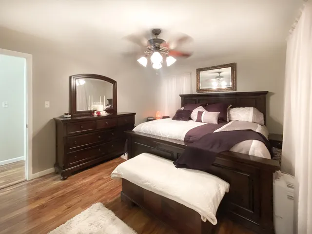 a bedroom with a bed and wooden floor