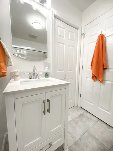a bedroom with a bed chandelier and a window