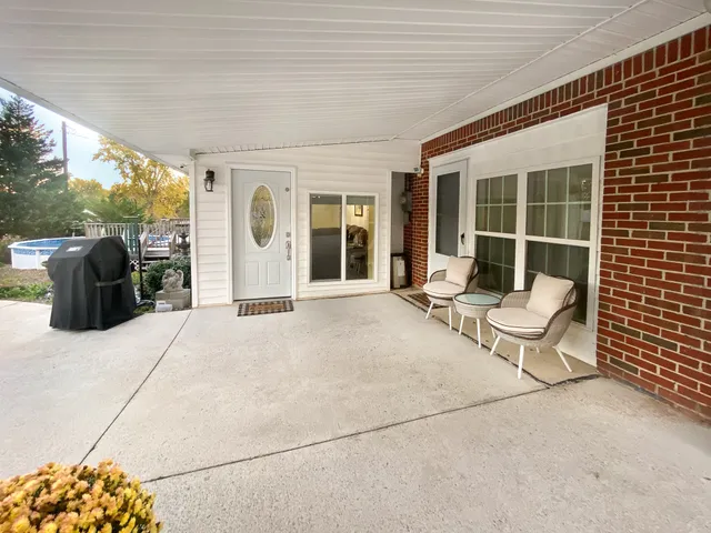 a view of house with backyard and sitting area