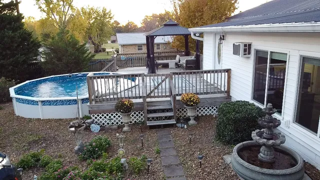 an aerial view of a house with swimming pool and large trees