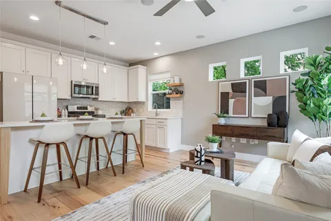 a kitchen with kitchen island granite countertop a sink and white cabinets
