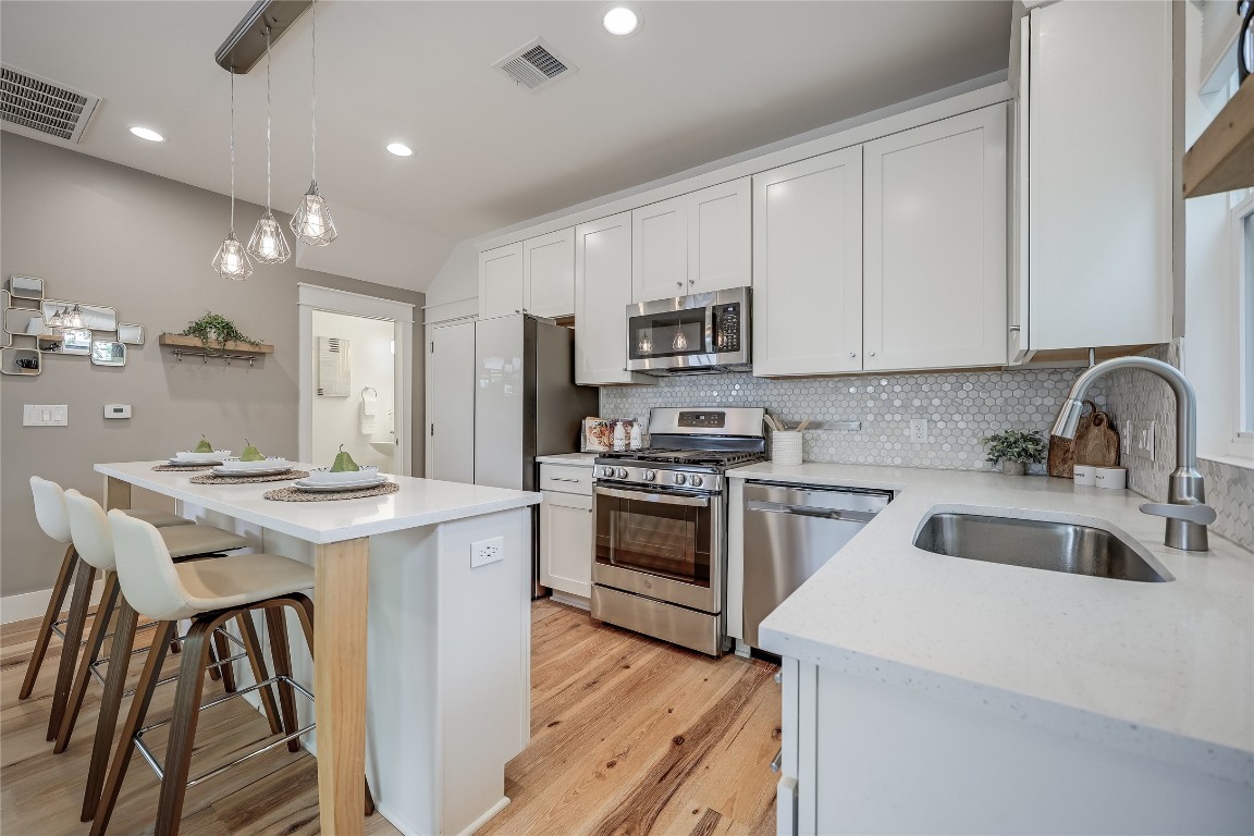 5512 Duval Street, Unit 2 Austin, TX 78751 - Photo 18 of 39 a kitchen with kitchen island a stove a sink a refrigerator and cabinets