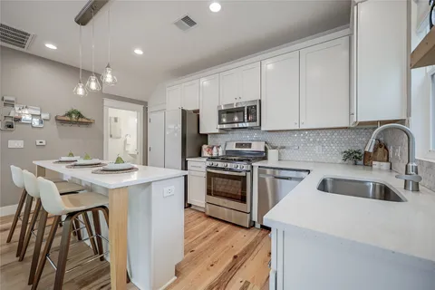 a kitchen with stainless steel appliances granite countertop a sink and a window