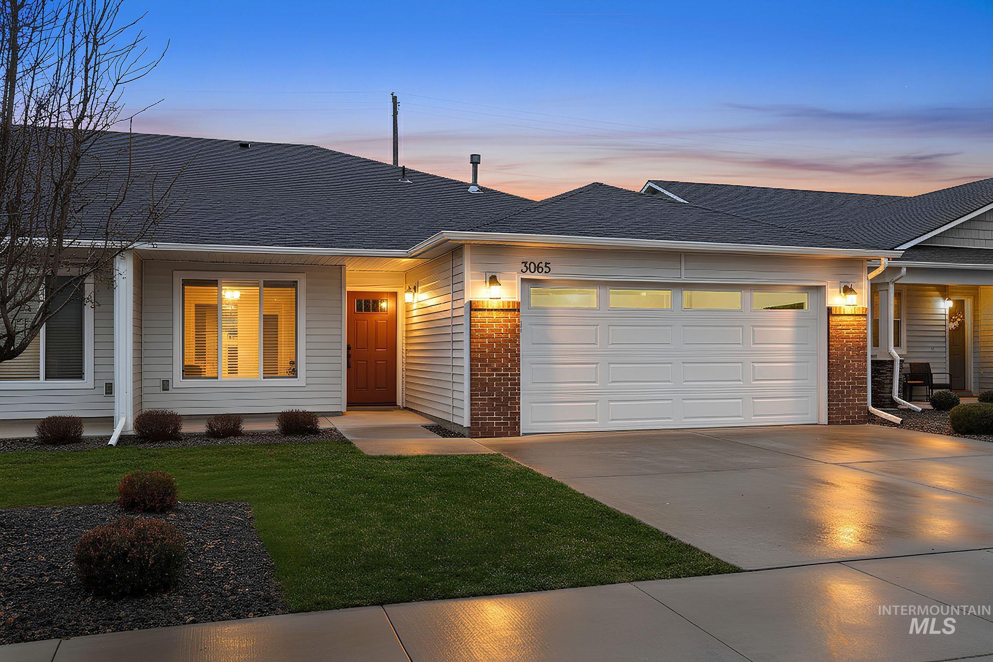 View of front facade with brick siding, concrete driveway, a garage, and roof with shingles