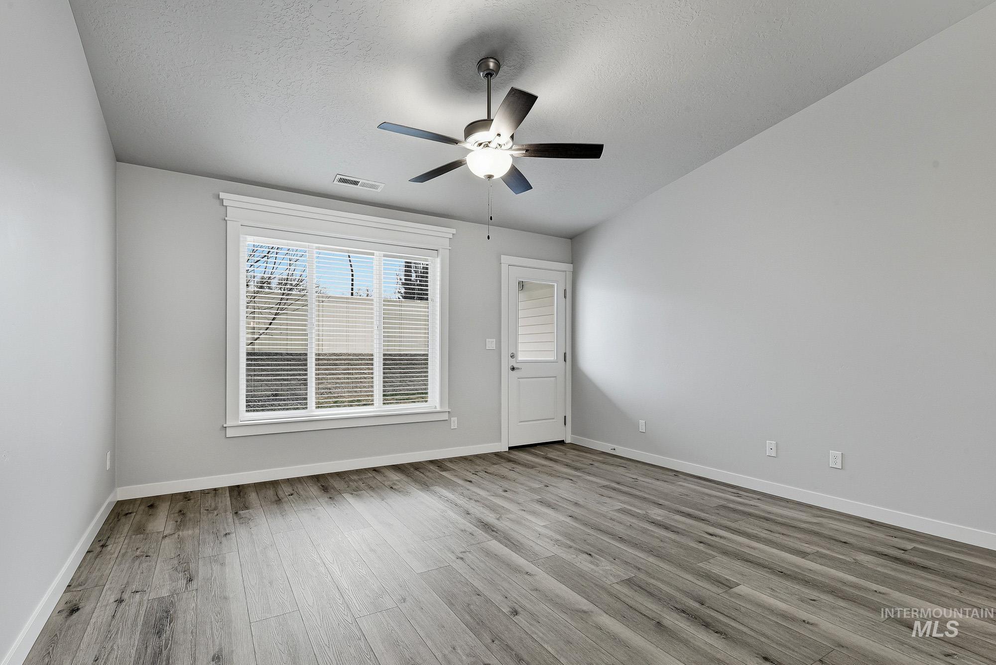 3065 North Summerbrook Avenue Meridian, ID 83646 - Photo 15 of 33 Spare room featuring light wood-style floors, ceiling fan, and a textured ceiling