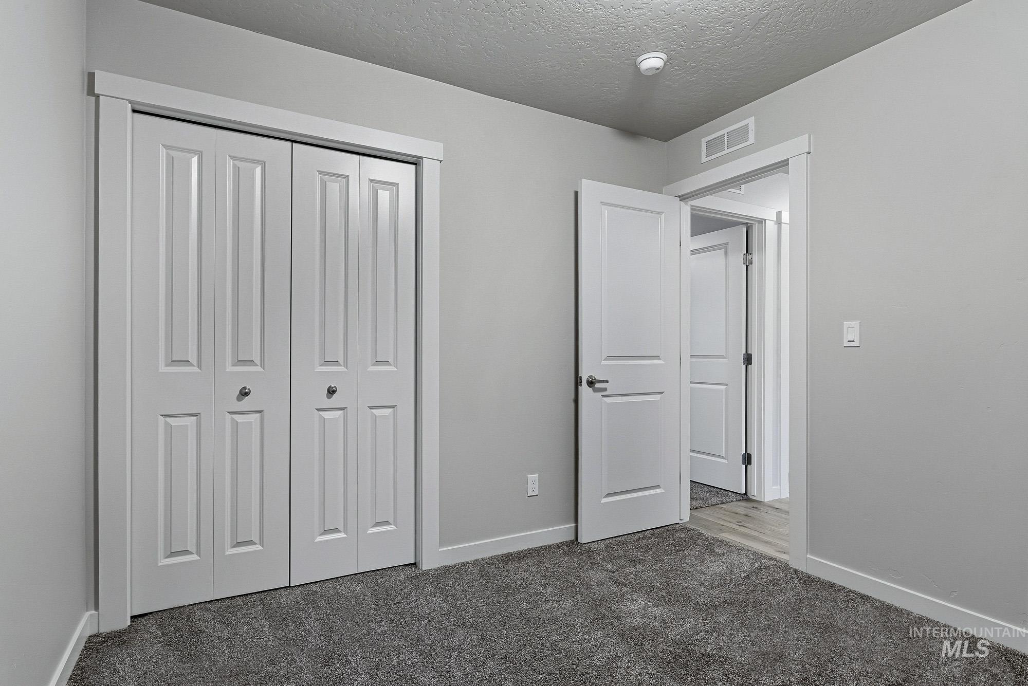 3065 North Summerbrook Avenue Meridian, ID 83646 - Photo 26 of 33 Unfurnished bedroom with carpet, a textured ceiling, and a closet
