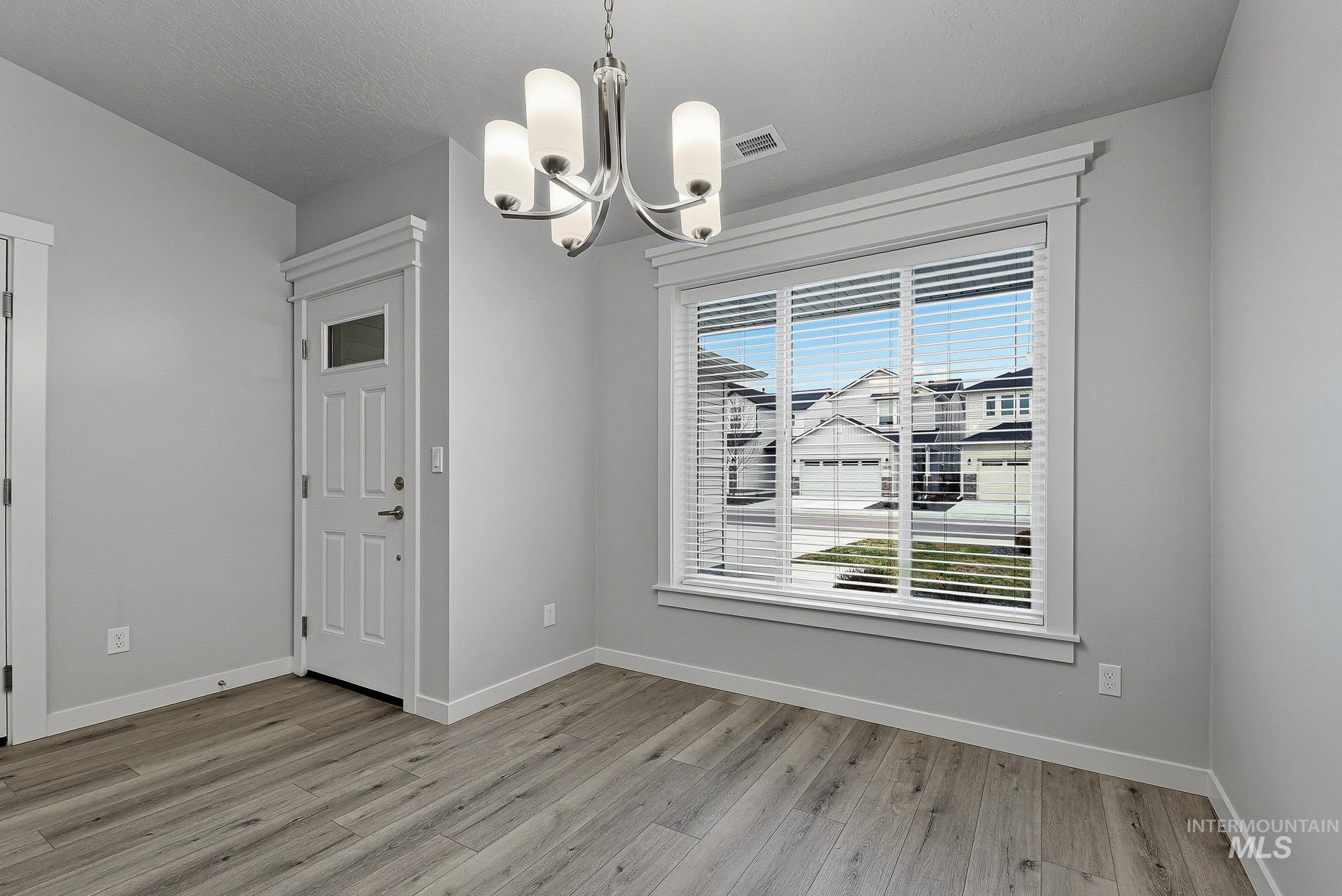 3065 North Summerbrook Avenue Meridian, ID 83646 - Photo 4 of 33 Unfurnished dining area featuring a chandelier and light wood-style floors