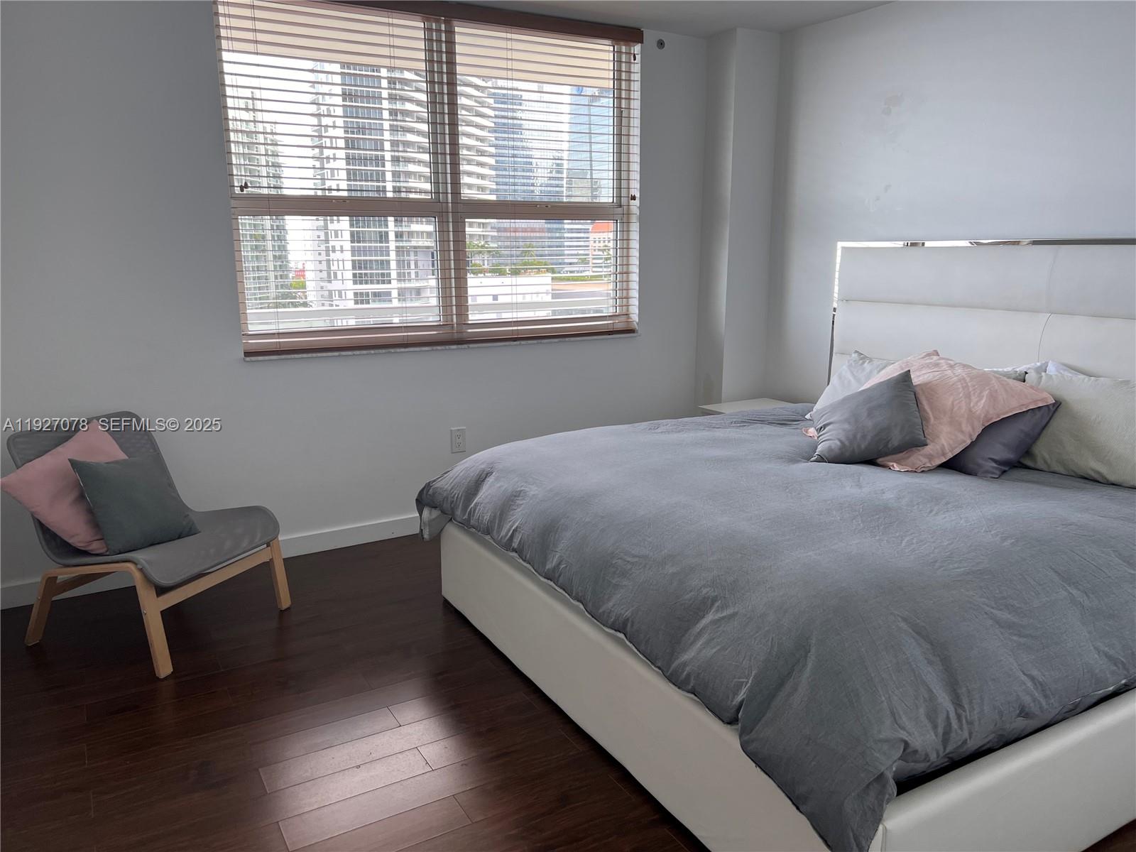 1155 Brickell Bay Drive, Unit 1607 Miami, FL 33131 - Photo 1 of 9 a bedroom with a bed and chair