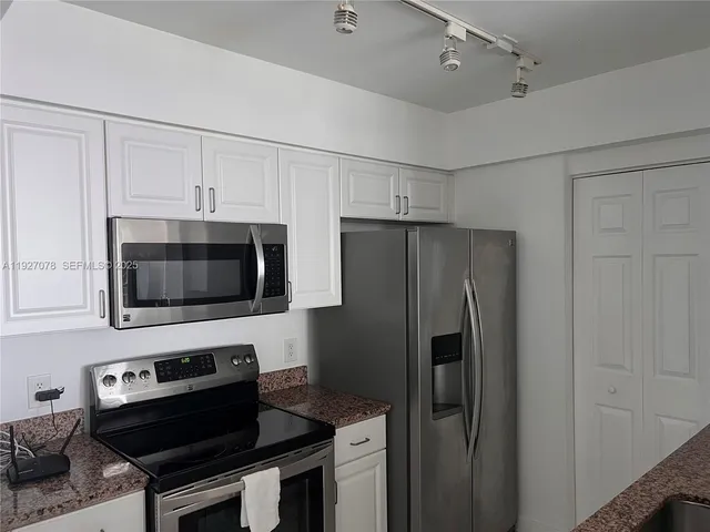 a kitchen with stainless steel appliances a stove a microwave and a refrigerator