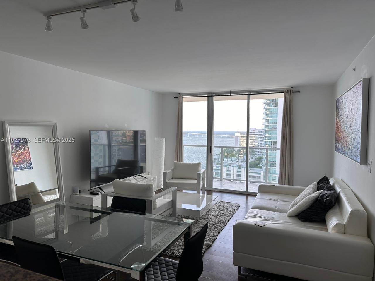 1155 Brickell Bay Drive, Unit 1607 Miami, FL 33131 - Photo 6 of 9 a living room with furniture and a large window