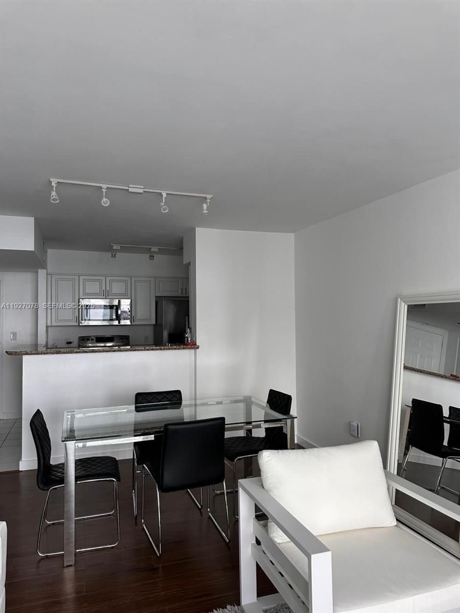 1155 Brickell Bay Drive, Unit 1607 Miami, FL 33131 - Photo 7 of 9 a kitchen with a table and chairs in it