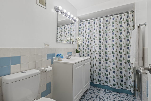 7540 North Ridge Boulevard, Unit 5D Chicago, IL 60645 - Photo 11 of 15 a bathroom with a sink toilet and shower