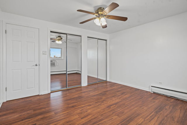 7540 North Ridge Boulevard, Unit 5D Chicago, IL 60645 - Photo 12 of 15 an empty room with wooden floor and ceiling fan