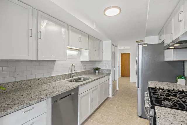 a view of a kitchen with a sink and a refrigerator
