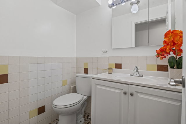 7540 North Ridge Boulevard, Unit 5D Chicago, IL 60645 - Photo 8 of 15 a bathroom with a sink toilet and vanity