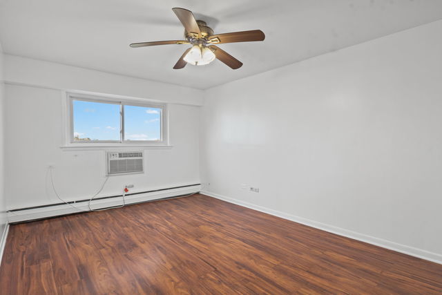 7540 North Ridge Boulevard, Unit 5D Chicago, IL 60645 - Photo 10 of 15 an empty room with wooden floor and windows
